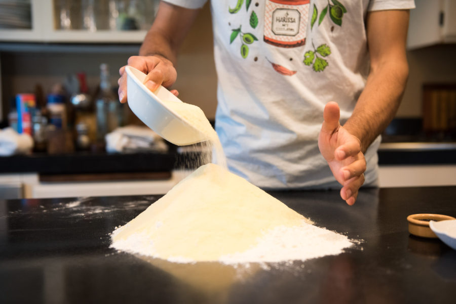 chef beginning the Batbout, Moroccan bread pouring flour on tabletop
