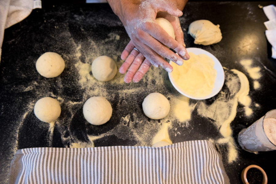 hands rolling balls of dough