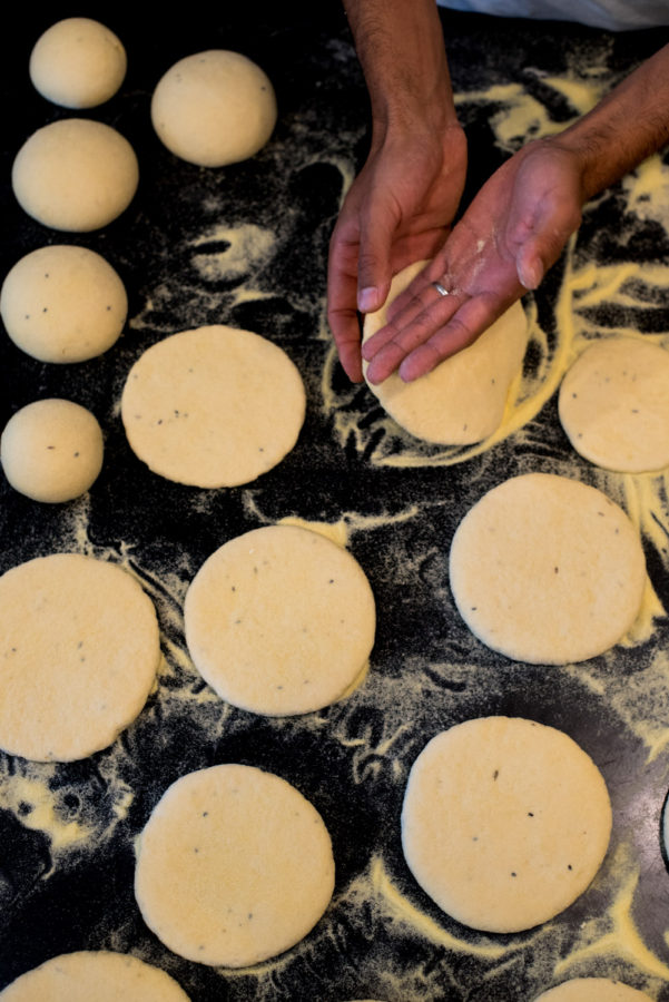 hands flatening balls of dough
