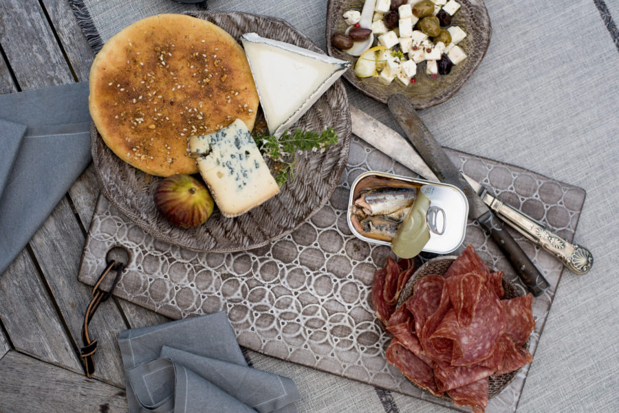 Bread, cheeses, salumi and sardines on a Madisone ware cheese plate