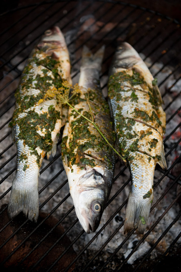 fish on grill covered in herbs